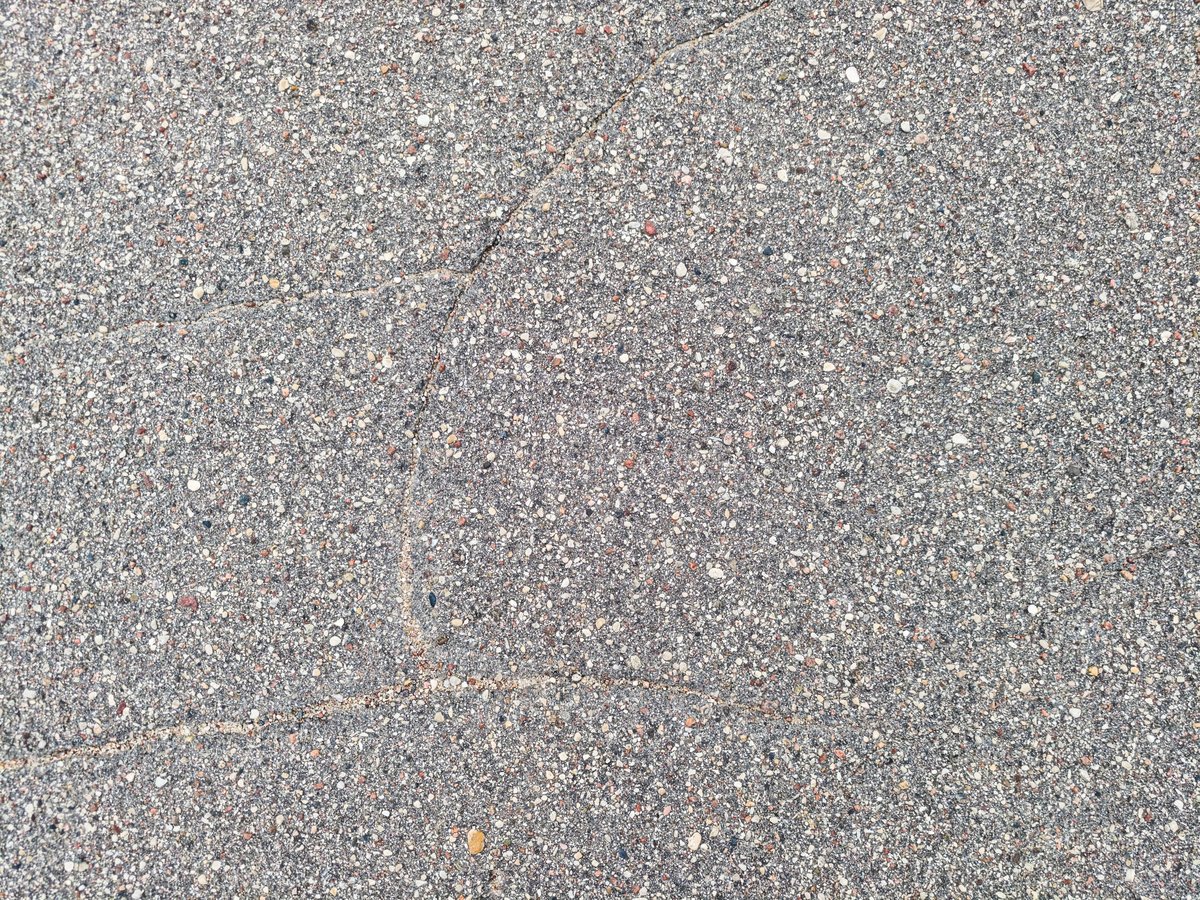 Close up of cracked asphalt pavement surface with rough texture