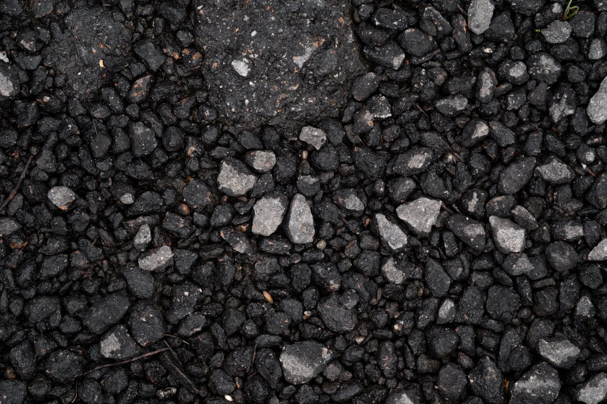 Close-up of dark asphalt with small grey stones visible