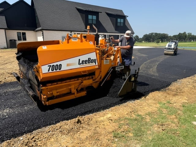 Orange Leebay 7000 asphalt paver machine working on residential driveway construction